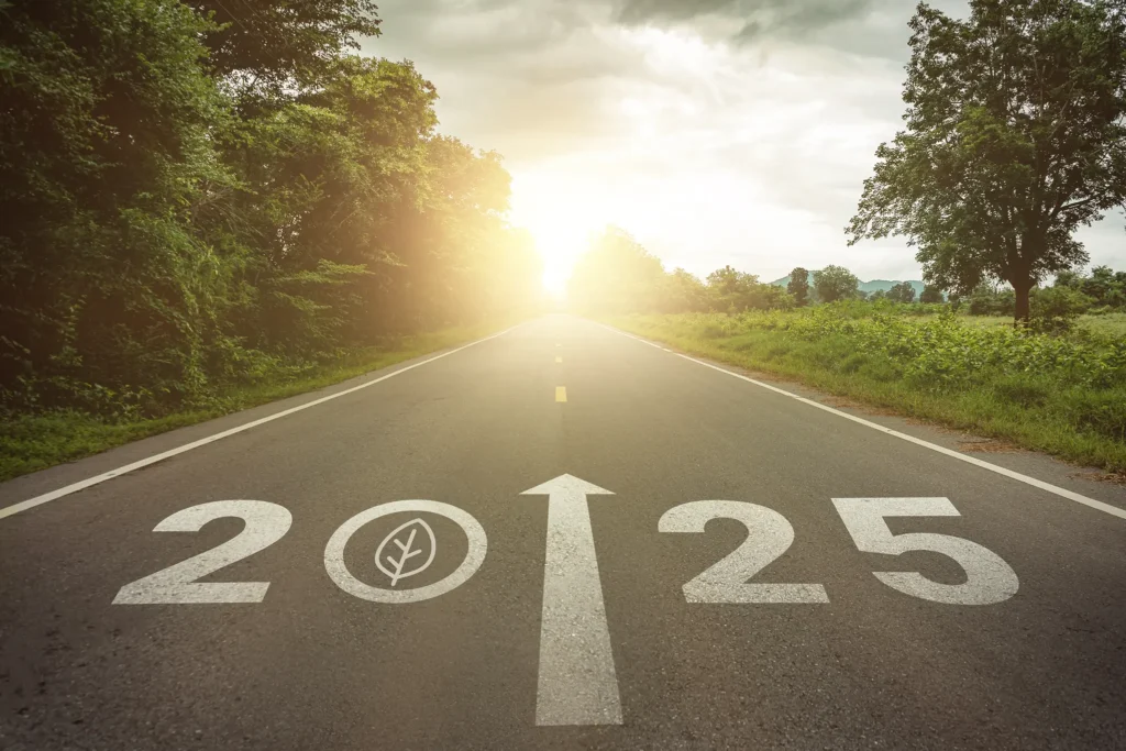 New year 2025 straightforward for environmental sustainability concept. Text 2025, save the world, leaf icon on the road in the middle of asphalt road at sunset. Ecological balance, sustainability.